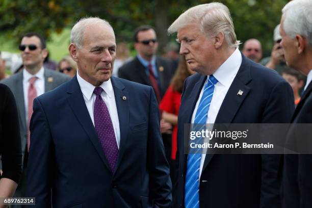 President Donald Trump stands with Secretary of Homeland Security John Kelly and Vice President Mike Pence after laying flowers on the grave of...