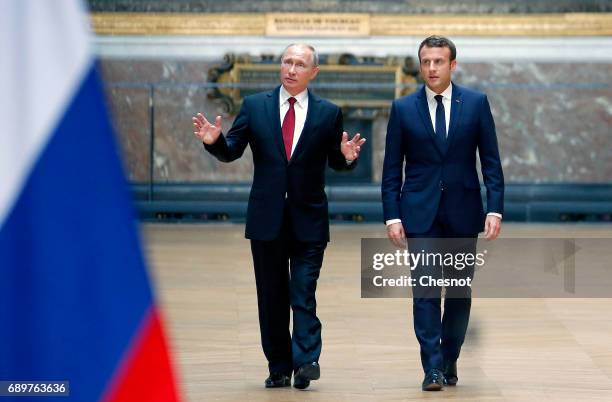 Russian President Vladimir Putin and French President Emmanuel Macron arrive to hold a joint press conference at "Chateau de Versailles" on May 29,...