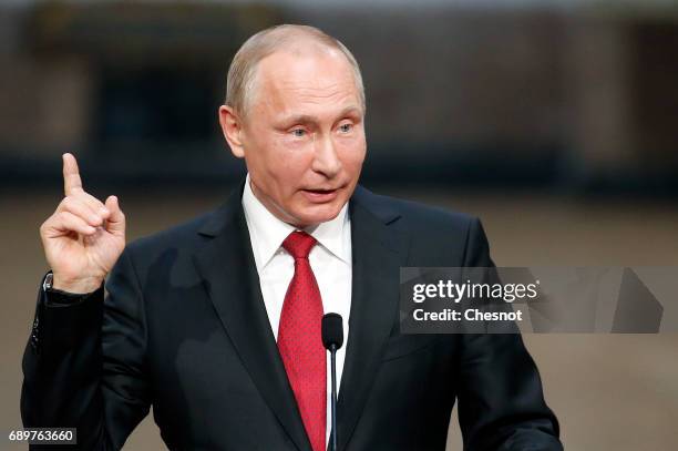 Russian President Vladimir Putin makes a statement during a joint press conference with French President Emmanuel Macron at "Chateau de Versailles"...