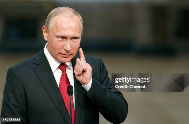 Russian President Vladimir Putin makes a statement during a joint press conference with French President Emmanuel Macron at "Chateau de Versailles"...