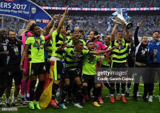 The Huddersield Town team celebrate with The Championship play off trophy after the Sky Bet Championship play off final between Huddersfield and...