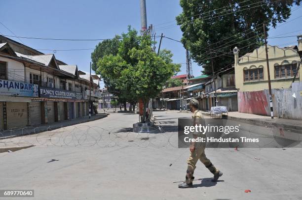 Policeman patrols near barbed wire set up as barricade during curfew on May 29, 2017 in downtown area of Srinagar, India. The government imposed...