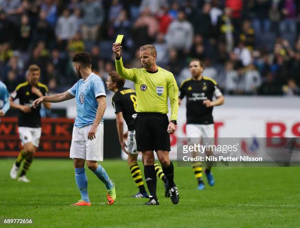 Erdal Rakip of Malmo FF is being shown a yellow card by Glenn Nyberg, referee during the Allsvenskan match between AIK and Malmo FF at Friends arena...