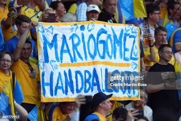 Fans of Braunschweig hold up a placard to tease Mario Gomez of Wolfsburg prior to the Bundesliga Playoff leg 2 match between Eintracht Braunschweig...