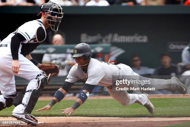 Starlin Castro of the New York Yankees scores against Caleb Joseph of the Baltimore Orioles off of a Aaron Hicks of the New York Yankees , sacrifice...