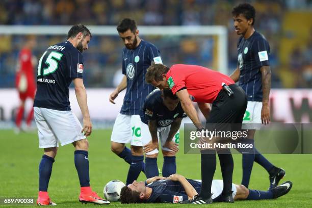 Team mates and referee Tobias Stieler look after Mario Gomez of Wolfsburg during the Bundesliga Playoff leg 2 match between Eintracht Braunschweig...