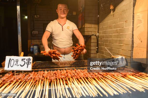 Typical stand/small street shop with Chinese cuisine specialities on display for sale, seen in Flavor Street, a local food street, in Wuhan center....