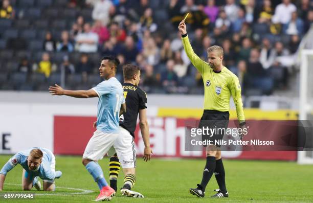 Yoshimir Yotún of Malmo FF is shown a yellow card by Glenn Nyberg, referee during the Allsvenskan match between AIK and Malmo FF at Friends arena on...