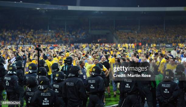 Fans of Braunschweig face police in riot gear after the Bundesliga Playoff leg 2 match between Eintracht Braunschweig and VfL Wolfsburg at Eintracht...