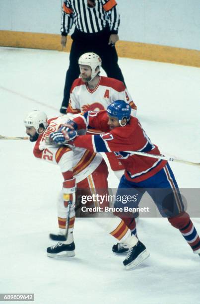 Craig Ludwig of the Montreal Canadiens battles with John Tonelli and Lanny McDonald of the Calgary Flames during a game in the 1986 Stanley Cup...