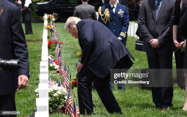 President Donald Trump lays down flowers on a grave at Section 60 of Arlington National Cemetery in Arlington, Virginia, U.S., on Monday, May 29,...