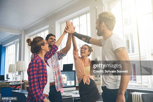 young business entrepreneurs celebrating a success - high five stockfoto's en -beelden