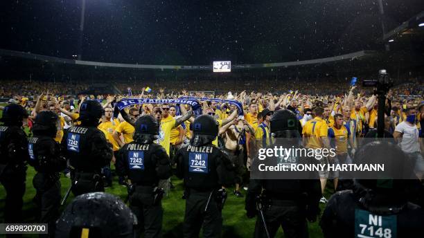 Disappointed supporters of Braunschweig enter the pitch after German Bundesliga relegation second leg football match between Eintracht Braunschweig...