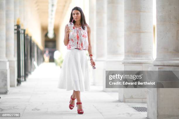 Kristina Castillo wears Furla sunglasses, a Benetton sleeveless white floral print top, a Maje pink shirt, Gucci red heels shoes, and a white lace...