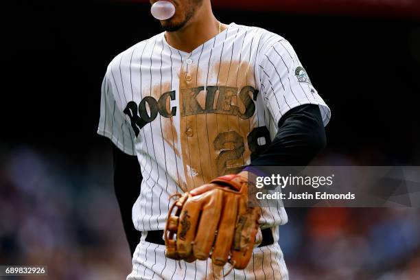 Nolan Arenado of the Colorado Rockies walks back to the dugout, blowing a bubble during interleague play against the Seattle Mariners at Coors Field...