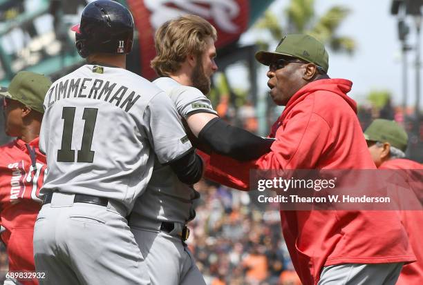 Manager Dusty Baker and Ryan Zimmerman of the Washington Nationals pulls Bryce Harper away from a fight after Harper was hit by a pitch from Hunter...