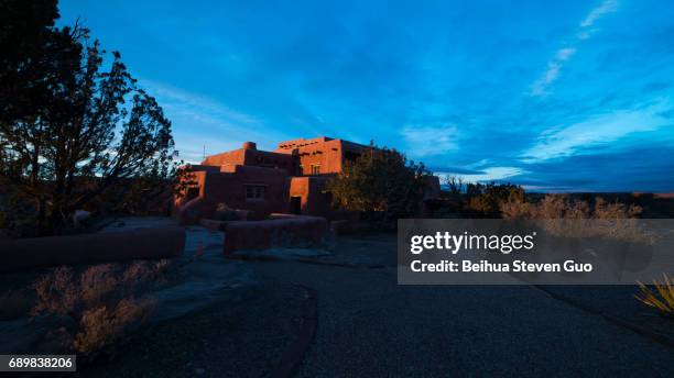 glowing red painted desert inn at sunrise in petrified forest national park, arizona - petrified wood stock-fotos und bilder