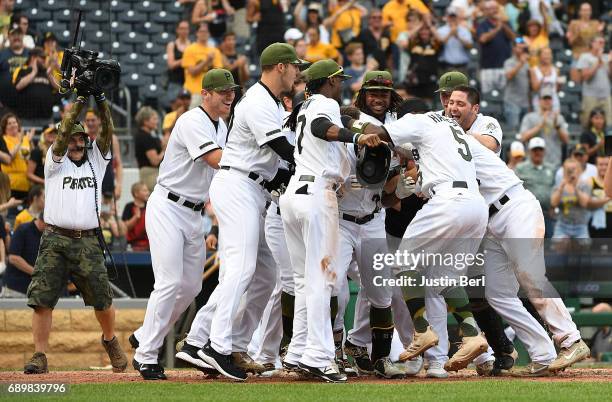Andrew McCutchen of the Pittsburgh Pirates is mobbed by teammates at home plate after hitting a walk off home run in the ninth inning to give the...