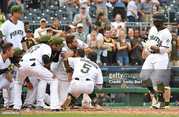 Andrew McCutchen of the Pittsburgh Pirates is met by teammates at home plate after hitting a walk off home run in the ninth inning to give the...