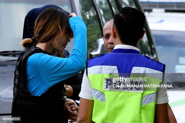 Vietnamese national Doan Thi Huong is escorted by Malaysian police for a court appearance with Indonesian national Siti Aisyah at the Sepang...