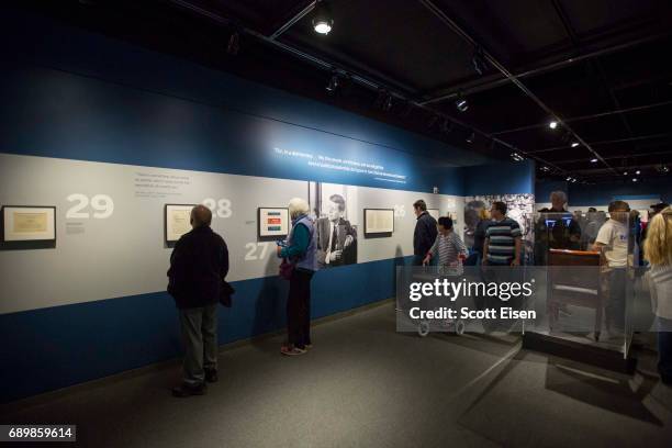 Guests check out various items from President John F. Kennedy's on display at the JFK 100: Milestones & Mementos Exhibit at the John F. Kennedy...