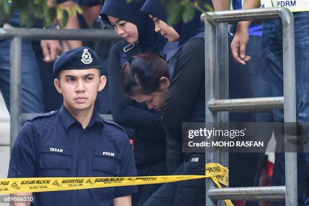 Indonesian national Siti Aisyah is escorted by Malaysian police after a court appearance with Vietnamese national Doan Thi Huong at the magistrates'...