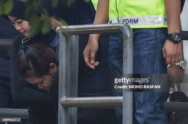 Indonesian national Siti Aisyah is escorted by Malaysian police after a court appearance with Vietnamese national Doan Thi Huong at the magistrates'...