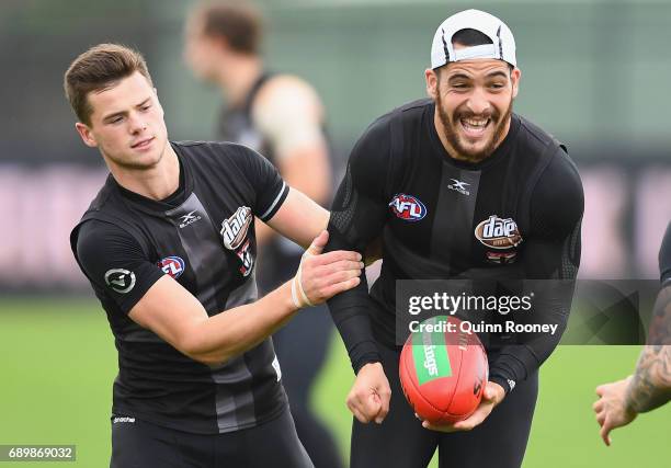 Shane Savage of the Saints handballs whilst being tackled Jack Sinclair during a St Kilda Saints AFL training session at Linen House Oval on May 30,...