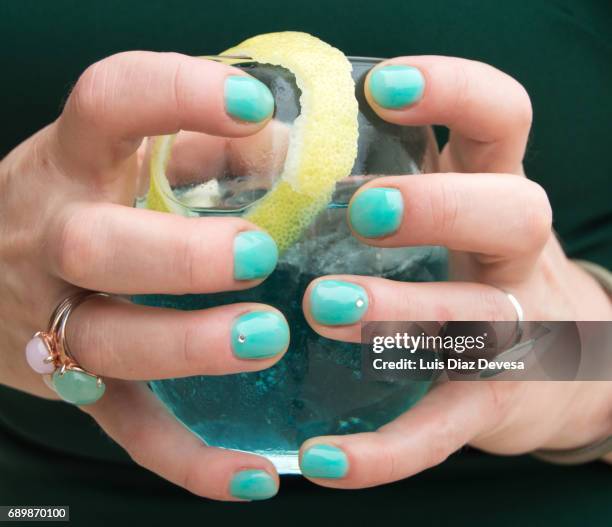 woman's hand holding cocktail  with green nails - green nail polish stock pictures, royalty-free photos & images