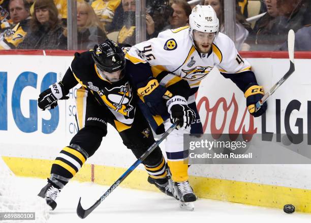 Justin Schultz of the Pittsburgh Penguins battles with Pontus Aberg of the Nashville Predators at the boards during the third period of Game One of...