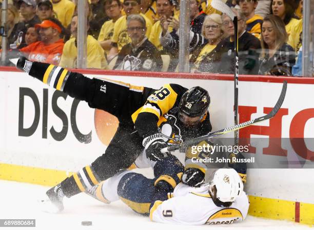 Ian Cole of the Pittsburgh Penguins falls to the ice after checking Filip Forsberg of the Nashville Predators to the boards during the third period...