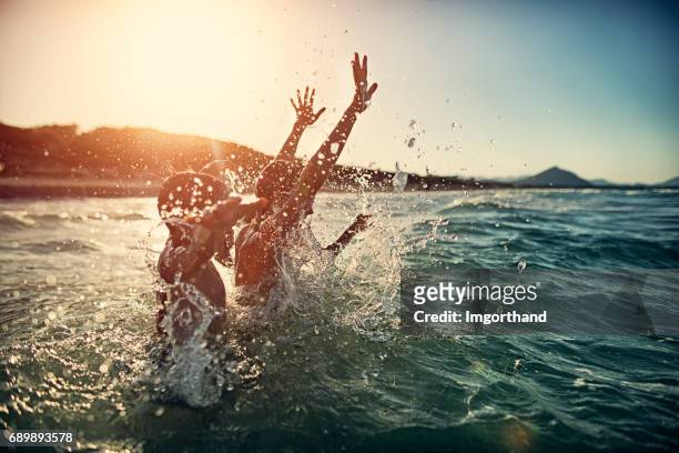 children splashing in summer sea - kid cheering stock pictures, royalty-free photos & images