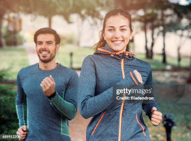 friends jogging in the park - couple running stock pictures, royalty-free photos & images