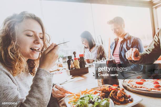 group of friends enjoying a meal in a restaurant. - gastro pub stock pictures, royalty-free photos & images