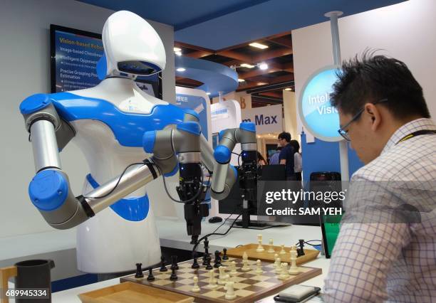 Visitor plays chess with a robot designed by Taiwan's Industrial Technology Research Institute during the Computex Show in Taipei on May 30, 2017....