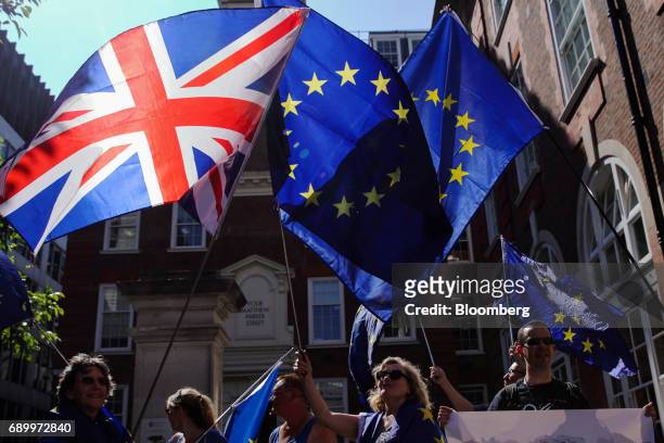 Campaigners wave an European Union flags and a Union flag, also known as a Union Jack, during an anti-Brexit demonstration outside the Conservative...