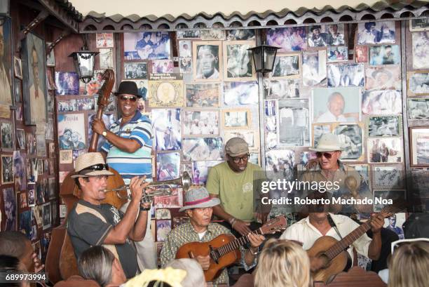 The 'Trova House' . Musicians playing their instruments in front of a wall covered with photos. Everyday scene of the open doors tourist attraction.