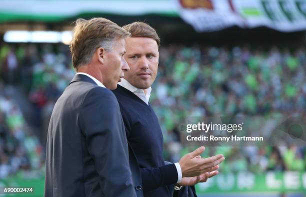 Sporting director Olaf Rebbe of Wolfsburg chats with head coach Andries Jonker of Wolfsburg prior to the Bundesliga Playoff first leg match between...