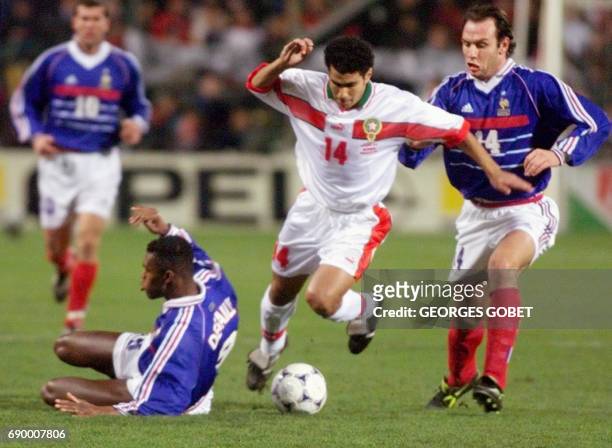 L'attaquant marocain Salahedine Bassir passe les défenseurs français Marcel Desailly et Alain Boghossian , le 20 janvier sur la pelouse du stade...