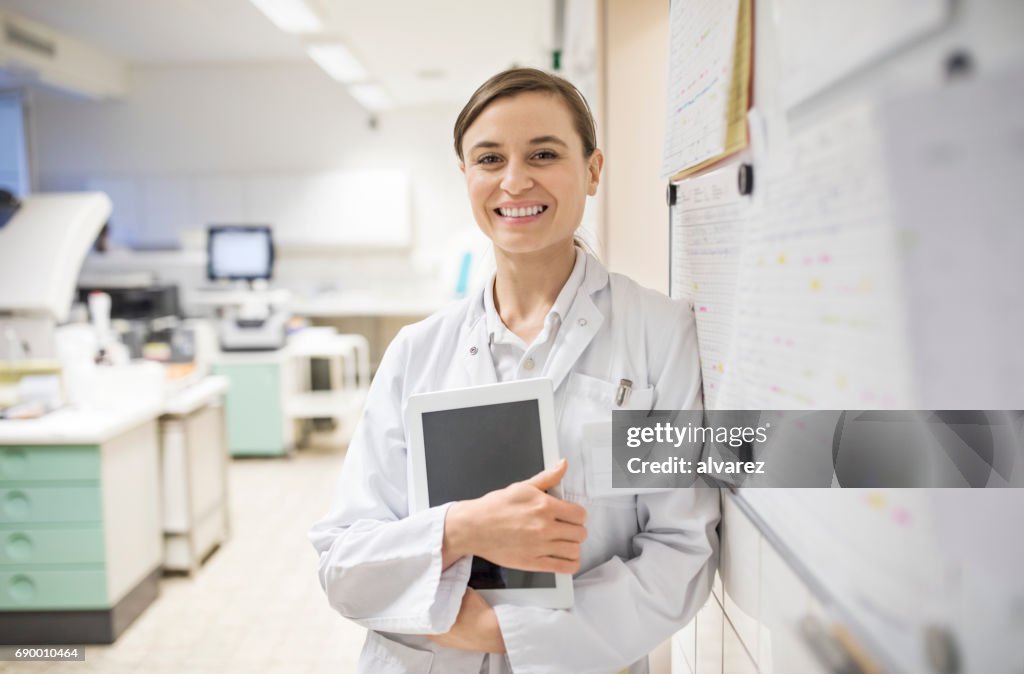 Lächelnde Wissenschaftlerin hält digital-Tablette