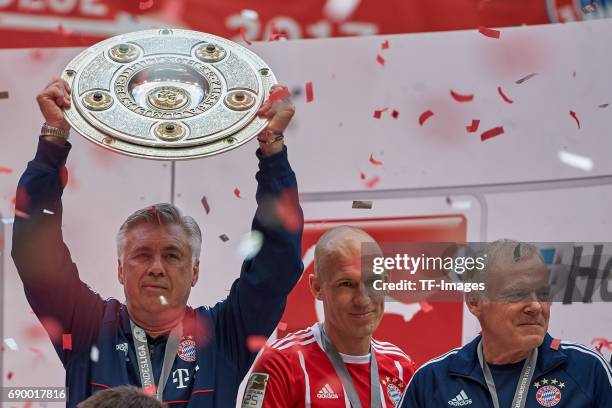 Head coach Carlo Ancelotti of Bayern Muenchen poses with the Championship trophy in celebration of the 67th German Championship title following...