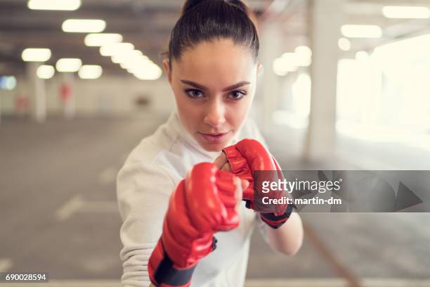 mujer joven en el gimnasio de boxeo - combat sport fotografías e imágenes de stock