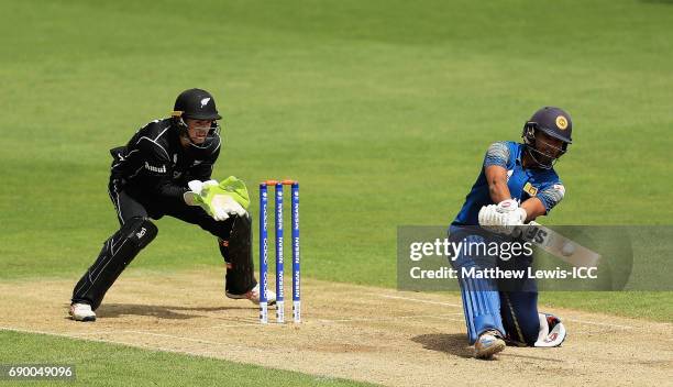 Dinesh Chandimal of Sri Lanka plays a reverse sweep, as Tom Latham of New Zealand looks on during the ICC Champions Trophy Warm-up match between New...