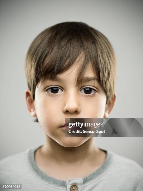 bambino carino che guarda la macchina fotografica - studio head shot serious confident looking at camera foto e immagini stock