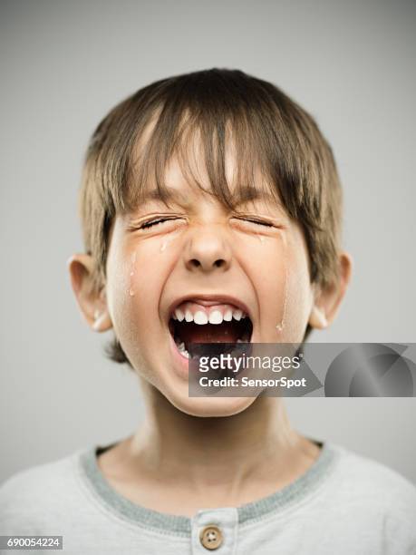sorglig liten pojke gråter högt - pain face portrait bildbanksfoton och bilder