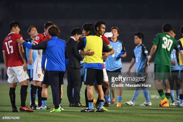 Kengo Nakamura of Kawasaki Frontale and Teerasil Dangda of Muangthong United hug after the AFC Champions League Round of 16 match between Kawasaki...