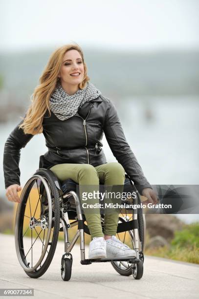 young woman using a wheelchair - diversamente abile stock-fotos und bilder