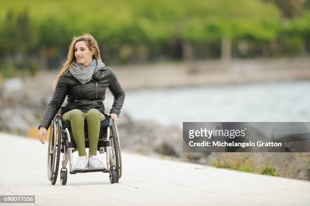 young woman using a wheelchair - determinazione fotografías e imágenes de stock