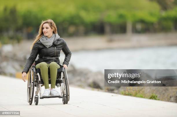 young woman using a wheelchair - coraggio stock pictures, royalty-free photos & images