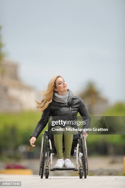 young woman using a wheelchair - determinazione fotografías e imágenes de stock